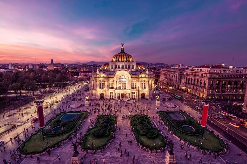 Fantastic view Mexico City's downtown at twilight. The nightlife of the city can be seen around the Palacio de Bellas Artes building in foreground. Courtesy Four Seasons
