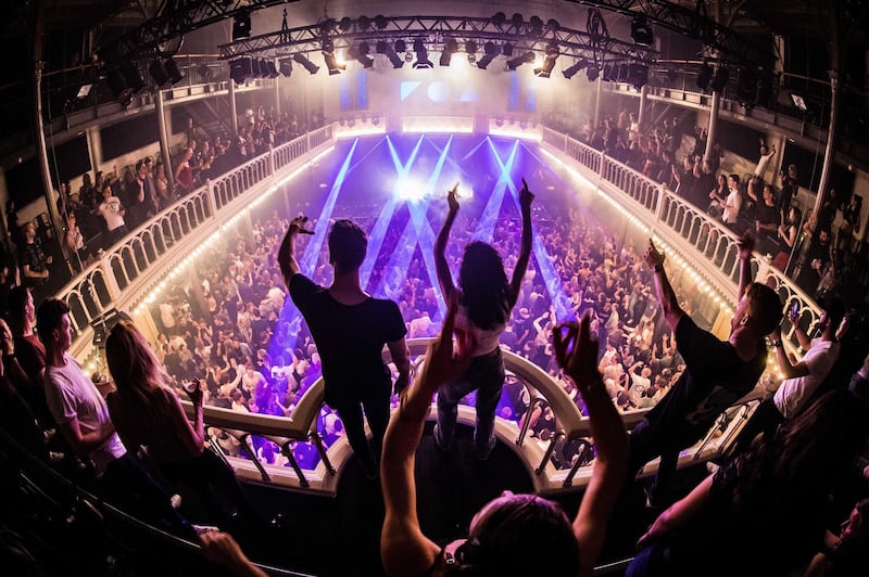 People react during a performance of Dj Reinier Zonneveld at the music venue Paradiso in Amsterdam, The Netherlands. The pop stage reopened its doors at full capacity to visitors, who have to show a negative test result in the CoronaCheck app as part of the venue's 'coronaproof' programme.  EPA