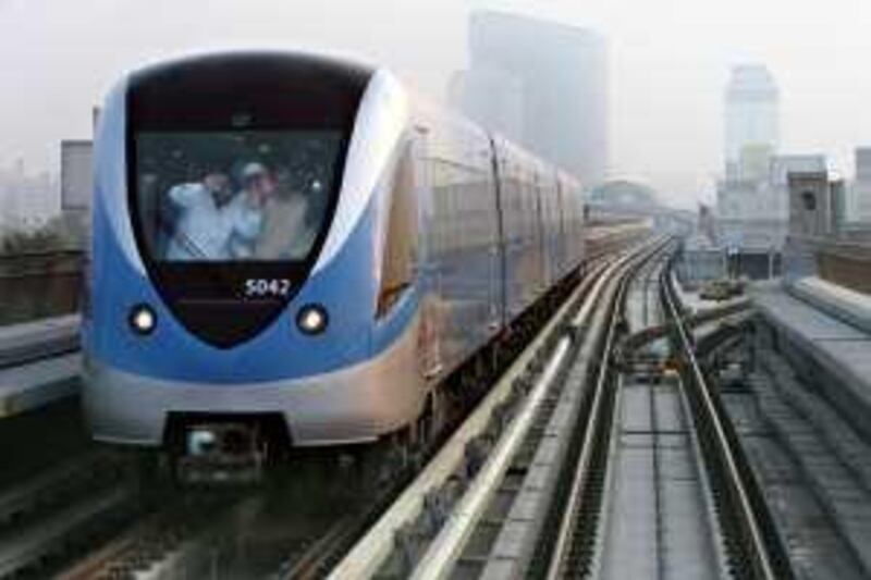 DUBAI, UNITED ARAB EMIRATES - SEPTEMBER 10:  Passengers wave from a passing train seen from on board the first train of the day on the Dubai Metro network which pulled out of the Nakheel  Harbour & Tower station at 6am in Dubai on September 10, 2009. Ten metro stations on the Red Line officially opened to the public this morning.  (Randi Sokoloff / The National)  For news story by Jonathan Gornall/Stock- Dubai Metro *** Local Caption ***  RS001-091009-METRO.jpg na11se-mainart1.jpg