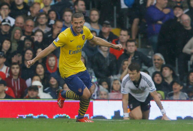 Arsenal's Lukas Podolski, left, celebrates his first goal against Fulham during their English Premier League soccer match at Craven Cottage, London, Saturday, Aug. 24, 2013. (AP Photo/Sang Tan) *** Local Caption ***  Britain Soccer Premier League.JPEG-09a83.jpg
