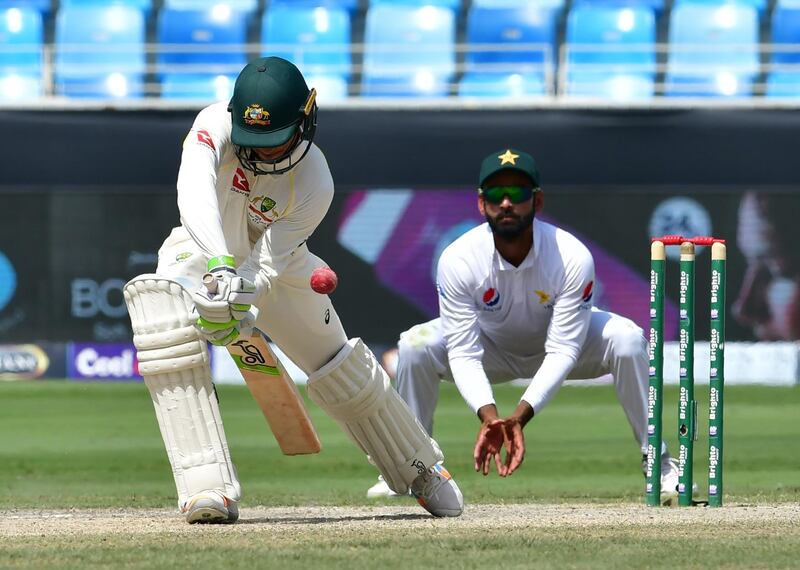 Australian cricketer Usman Khawaja (L) plays a shot during the fifth day of play of the first Test cricket match in the series between Australia and Pakistan at the Dubai International Stadium in Dubai on October 11, 2018. / AFP / GIUSEPPE CACACE
