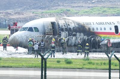 Rescue workers are seen at the site where a Tibet Airlines plane caught fire after an aborted takeoff at Chongqing Jiangbei International Airport in Chongqing, China, on May 12. via Reuters   