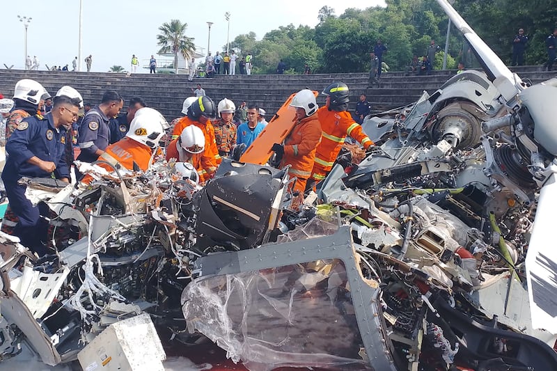 Rescuers inspecting the crash site after two military helicopters collided in Lumut in Malaysia's Perak state. AFP