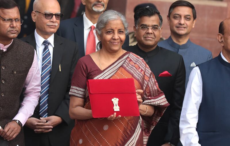 Indian Finance Minister Nirmala Sitharaman (centre) holds a folder containing Union Budget documents outside the Ministry of Finance in New Delhi, on Tuesday before the budget's presentation in Parliament. EPA