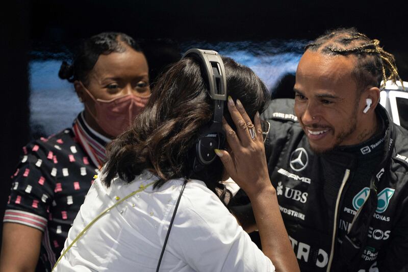 Former US First Lady Michelle Obama speaks with Mercedes driver Lewis Hamilton. AFP