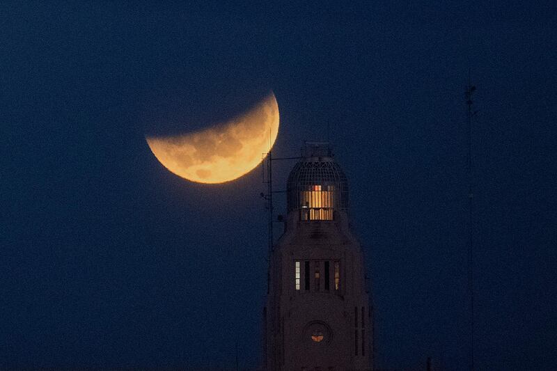 The Moon sets behind Montevideo port in Uruguay during a lunar eclipse, also known as a super blood moon. AP Photo