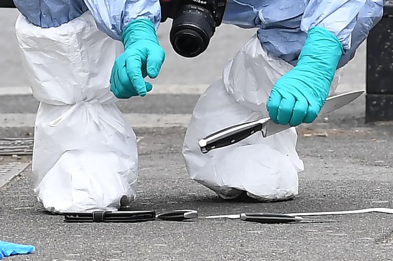 (FILES) In this file photo taken on April 27, 2017 a British police forensics officer holds a knife as evidence is collected on Whitehall near the Houses of Parliament in central London, at the scene where Khalid Mohammed Omar Ali was detained and taken away by police. Khalid Mohammed Omar Ali was on June 26, 2018, found guilty of plotting a knife attack on MPs and police outside the Houses of Parliament. / AFP / Justin TALLIS
