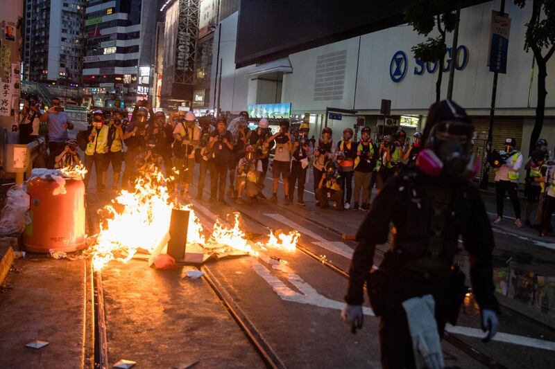 A demonstrator walks past a burning barricade during a protest in the Admiralty district of Hong Kong. Bloomberg