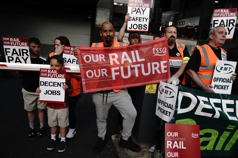 Members of the Transport Salaried Staffs' Association (TSSA) and the Rail, Maritime and Transport union (RMT) are joined by their families on the picket line outside Euston station in London. PA