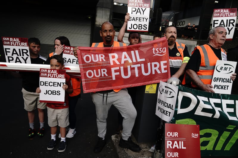 Members of the Transport Salaried Staffs' Association and the RMT are joined by their families on the picket line outside London Euston train station. PA