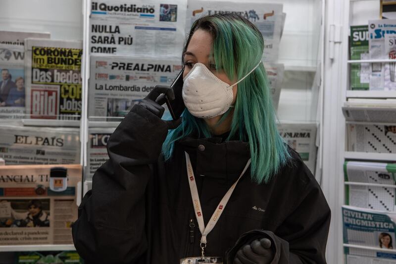 MILAN, ITALY - MARCH 11: A newsagent speaks over the ohone inside her news kiosk on March 11, 2020 in Milan, Italy. The Italian Government has strengthened up its quarantine rules, shutting all commercial activities except for pharmacies, food shops, gas stations, tobacco stores and news kiosks in a bid to stop the spread of the novel coronavirus. (Photo by Emanuele Cremaschi/Getty Images)
