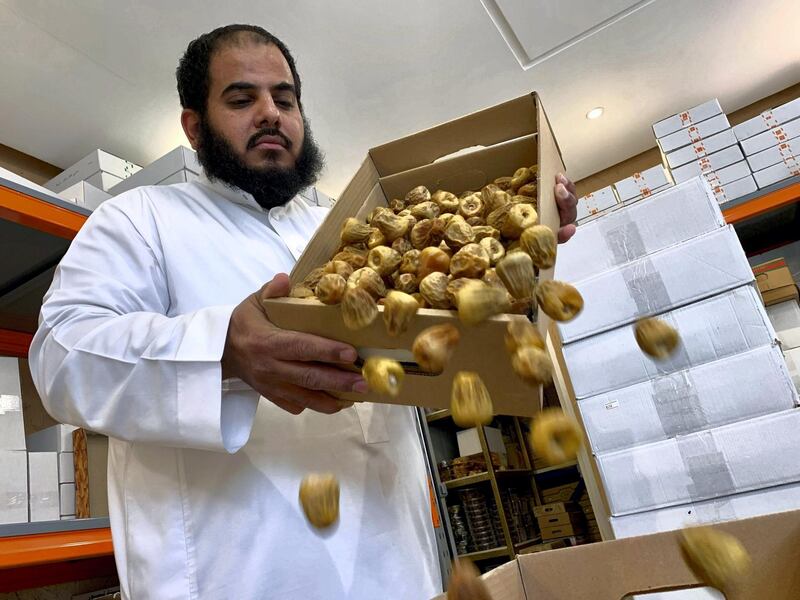 A Saudi seller pours dates into a box at his shop, during the 24-hours lockdown to counter the coronavirus disease (COVID-19) outbreak, ahead of the holy fasting month of Ramadan, in Riyadh, Saudi Arabia April 20, 2020. Picture taken April 20, 2020. REUTERS/Nael Shyoukhi