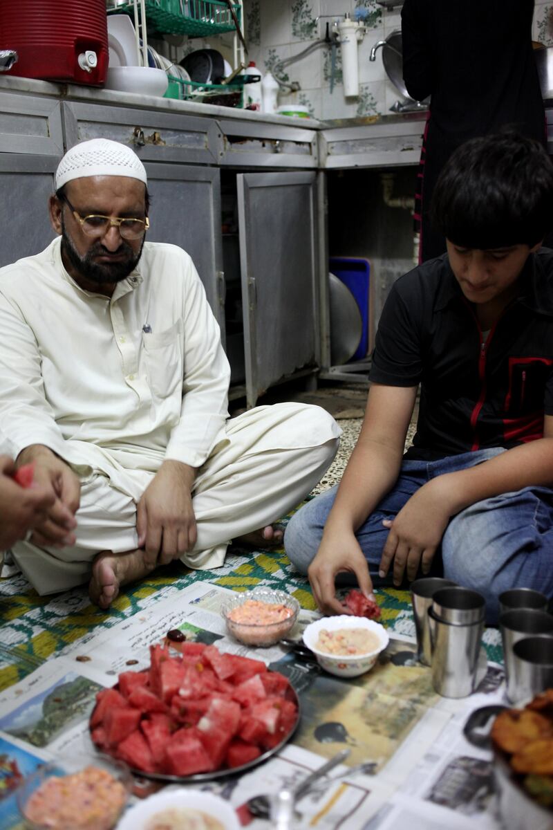 August 16 2011 -Shahama, UAE- Sarkai Khan and Abdulrahman Khan (15) break their fast on watermelon at their home in Old Shahama. "I was the first Pakistani in Shahama 20 years ago, but I have lived in the UAE for 37 years. UAE to me is like Peshawar, it's my home", he says. Sarkai has 4 sons and 4 daughters and they all live together in a small ground floor house in Old Shahama. (Razan Alzayani / The National) 