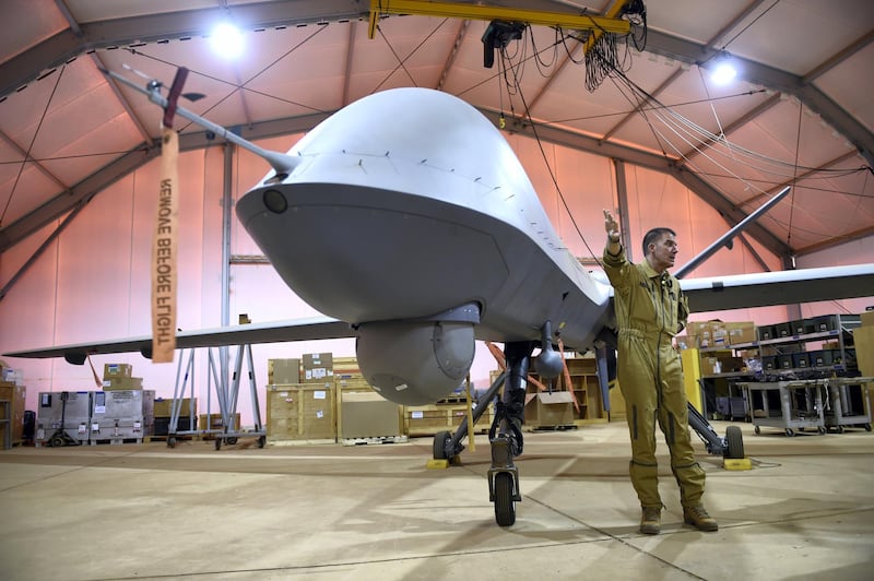 Colonel Eric Bometon, commander of the "Detachement Air" (DetAir) of the Operation Barkhane, an anti-terrorist operation in the Sahel, presentes an US-made drone Reaper bought by the French military, on June 9, 2015 in the  French army base in Nianey, Niger.    AFP PHOTO/PHILIPPE DESMAZES (Photo by PHILIPPE DESMAZES / AFP)