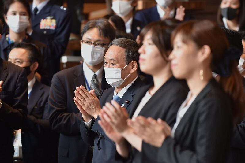 Japan’s Chief Cabinet Secretary Yoshihide Suga applauds with others as outgoing Prime Minister Shinzo Abe bids farewell to the staff members after his last cabinet meeting in Tokyo.  AFP