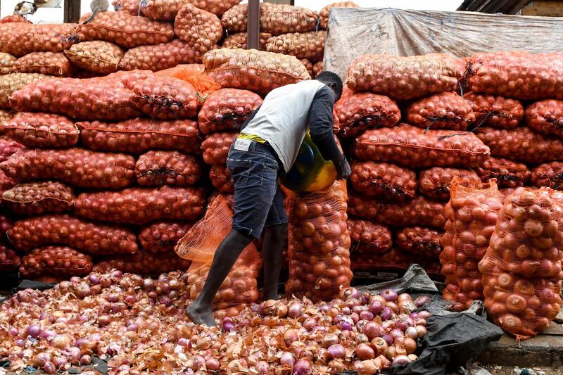 A seller packs onions in a bag in Camberene market in Dakar. AFP