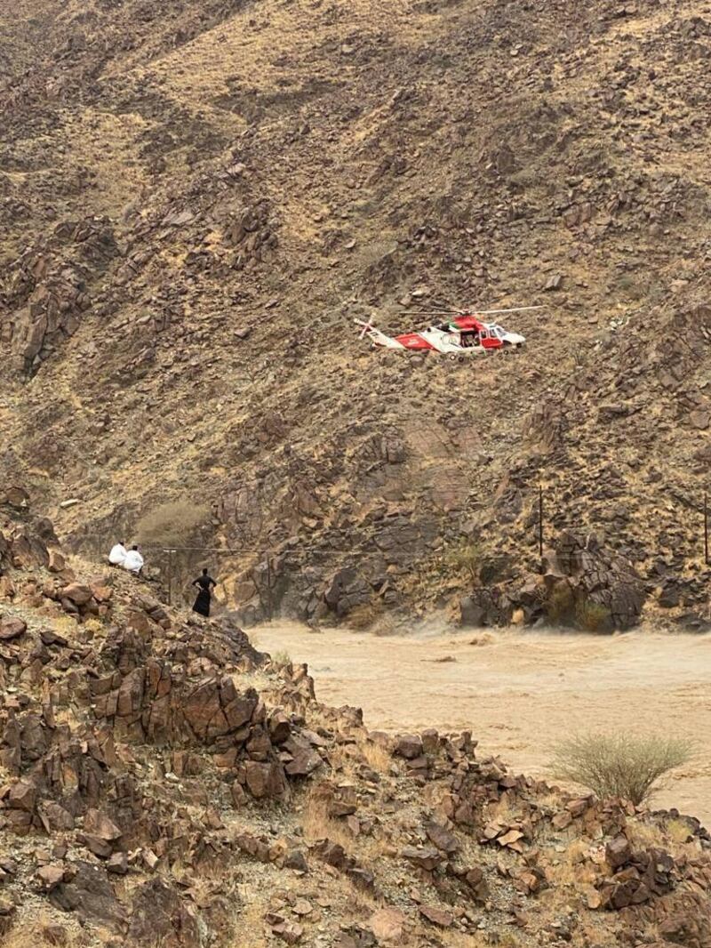 A search and rescue helicopter hovers over a flooded wadi near the village of Wadi Al Helo on the east coast. Courtesy: Sharjah Police