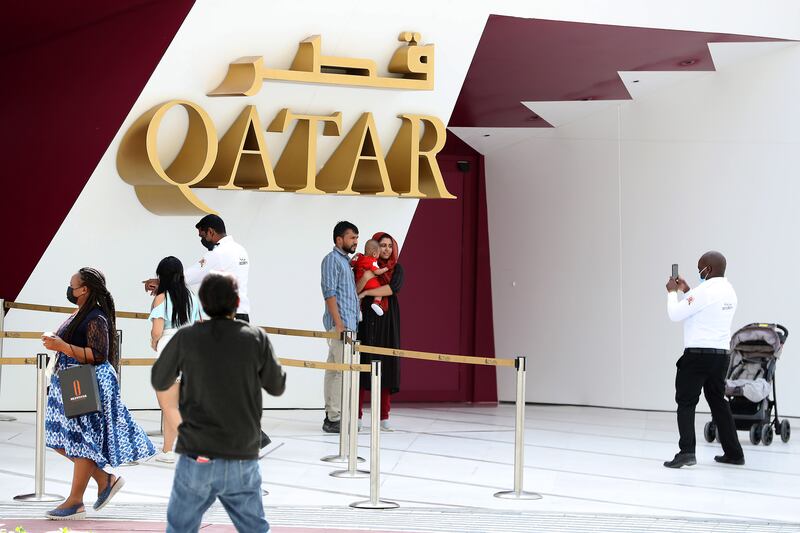 Visitors get their picture taken outside the Qatar pavilion