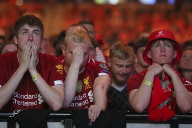 Liverpool supporters react as Real Madrid win the Champions League Final as they look at a large screen at M&S Bank Arena in Liverpool, England, Saturday, May 28, 2022.  The Champions League final soccer match between Liverpool and Real Madrid that is being played at the Stade de France in Saint Denis near Paris.  Madrid won the match 1-0.  (AP Photo / Scott Heppell)