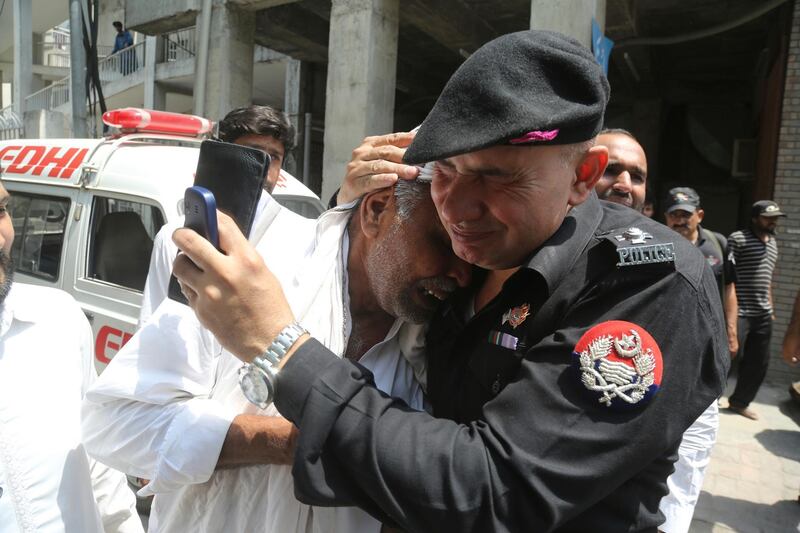 A police officer comforts a man who lost his family member outside a hospital in Lahore, Pakistan. A suicide bomber attacked security forces guarding a famous Sufi shrine in Pakistan's eastern city of Lahore, police said.  AP Photo