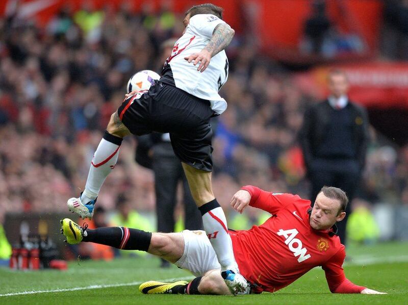 Manchester United forward Wayne Rooney, right, challenges Liverpool defender Daniel Agger. Paul Ellis / AFP / March 16, 2014