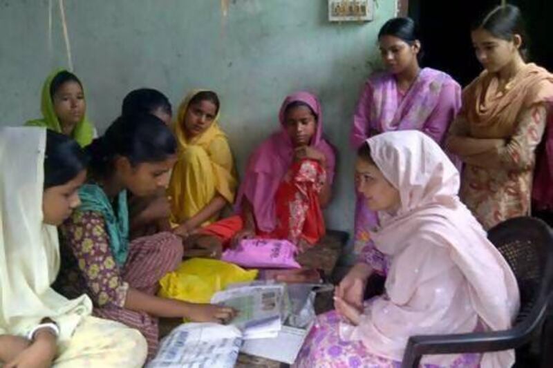 Ruksar Bano reads out a Hindi newspaper to UAE resident Shazia Kidwai, (seated on the right), who runs a literacy program in her home state of Uttar Pradesh in India aimed at helping young girls. Courtesy Shazia Kidwai