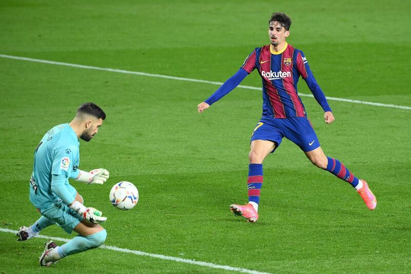 Alaves goalkeeper Fernando Pacheco stops a shot on goal by Barcelona's Portuguese forward Francisco Trincao. AFP