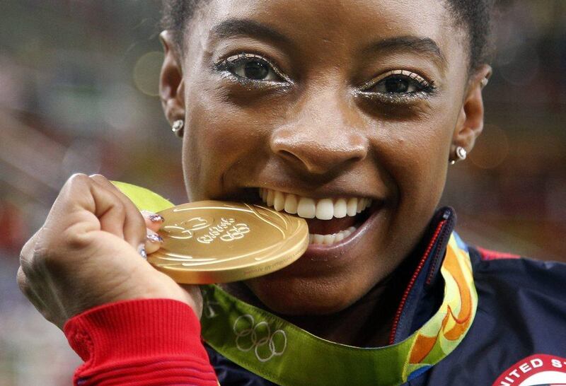 United States gymnast Simone Biles bites her gold medal for the artistic gymnastics women’s individual all-around final at the 2016 Summer Olympics in Rio de Janeiro, Brazil. Bridles was selected as the AP Female Athlete of the Year, on Monday, December 26, 2016. Dmitri Lovetsky / AP