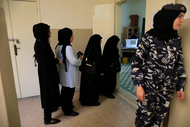 A Lebanese policewoman, right, stands next to women who are queuing to cast their vote at a ballot station during the Lebanon's parliamentary elections in a southern suburb of Beirut, Lebanon. Hassan Ammar / AP Photo