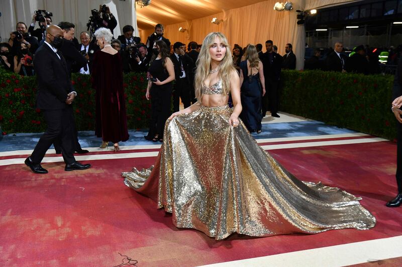 Singer and actress Sabrina Carpenter wearing a gold skirt and bralette top. AFP