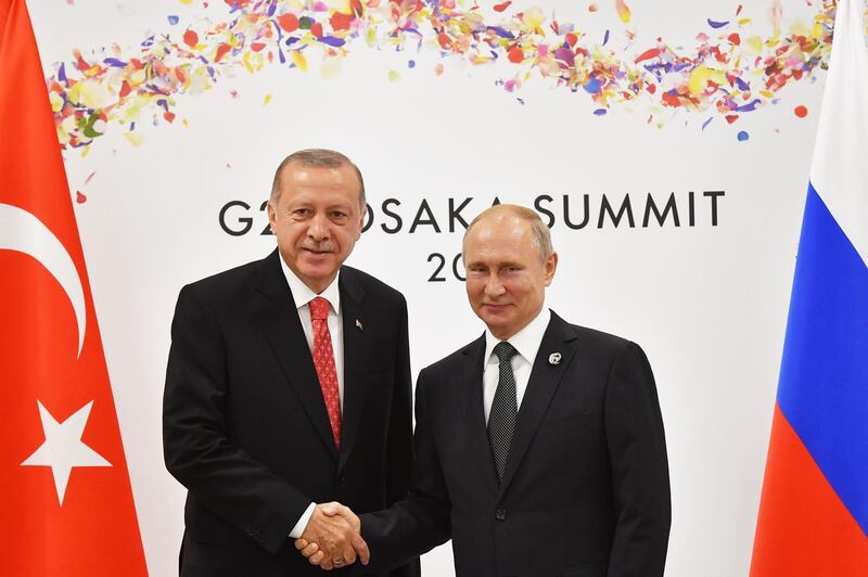 (FILES) In this file photo taken on June 29, 2019, Russian President Vladimir Putin greets Turkish President Recep Tayyip Erdogan on the sidelines of the G20 leaders summit in Osaka, Japan. Turkey received the first batch of Russia's S-400 missile defence system on July 12, 2019, the defence ministry said, after the purchase caused tensions in relations with its NATO ally the United States. / AFP / POOL / Yuri KADOBNOV
