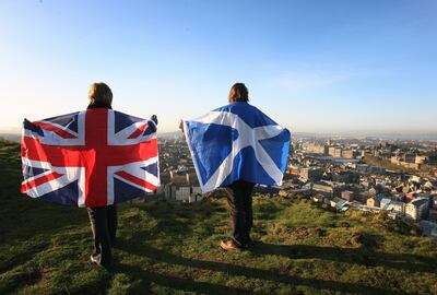 Scottish and English flags held up over Edinburgh, Scotland. A poll says more than half of people in Scotland do not want another independence referendum next year. PA