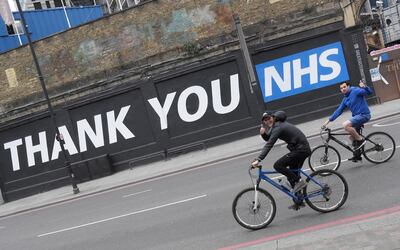 Cyclists gesture as they pass a thank you message for the NHS in East London following the outbreak of the coronavirus disease (COVID-19), London, Britain, May 10, 2020. REUTERS/Toby Melville