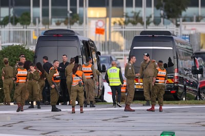 Israeli security forces stand next to buses waiting at the helipad of Tel Aviv's Schneider medical centre in preparation for the release of Israeli hostages held by Hamas in Gaza. AFP
