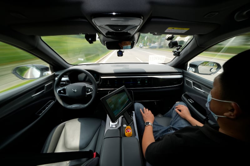 A technician monitors the self-driving taxi developed by tech giant Baidu.  AP