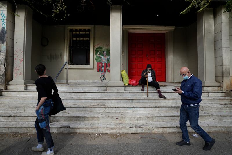 People pass in front of a beggar, centre, on Hamra Street. Fuelled by massive debt and the unsustainable way it was financed, the crisis has slashed Lebanon's gross domestic product by 58.1% since 2019, the World Bank said.