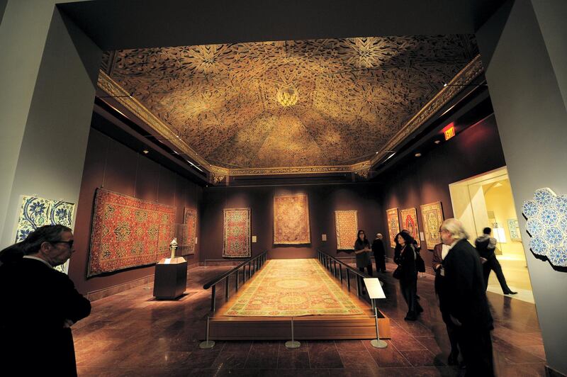 Visitors look at ancient artifacts during a press preview of new galleries for the Art of the Arab Lands, Turkey, Iran, Central Asia, and Later South Asia at the Metropolitan Museum of Art  in New York, October 24, 2011. After a eight-year construction project, The Metropolitan Museum of Art will open on November 1, 2011, a suite of 15 newly transformed galleries to house its collection of Islamic art. Through the new installation of some 1,200 works of art--including carpets, jewels, a luxurious room setting, illustrated manuscripts, and spectacular works in metal and glass--the rich diversity of the Islamic world will be emphasized.  AFP PHOTO/Emmanuel Dunand (Photo by EMMANUEL DUNAND / AFP)