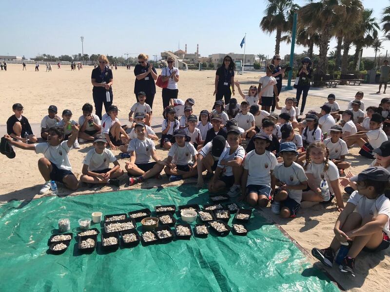 Year Five students at Umm Sequim Beach, Dubai, with the some of the cigarette butts they discovered during a clean-up.