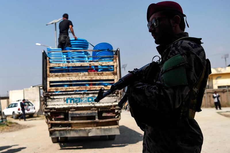 A security personnel stands guard as Independent Election Commission (IEC) workers unload ballot boxes from a truck to be taken to a counting centre the day after Afghanistan held presidential elections, in Kabul. AFP