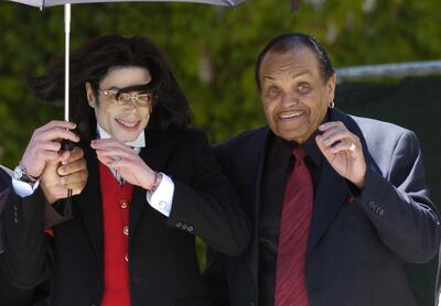 FILE PHOTO:  Pop star Michael Jackson and his father Joe Jackson gestures to his fans as he leaves the Santa Barbara county courthouse in Santa Maria, California.   REUTERS/Phil Klein/File Photo