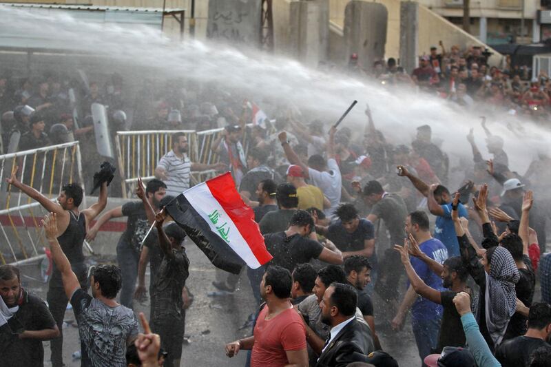Iraqi protesters chant slogans and wave national flags in the capital Baghdad's Tahrir Square. AFP
