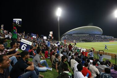 Fans watch the IPL opening match between Mumbai Indians vs Kolkata Knight Riders at Zayed Cricket Stadium in Abu Dhabi. Pawan Singh / The National