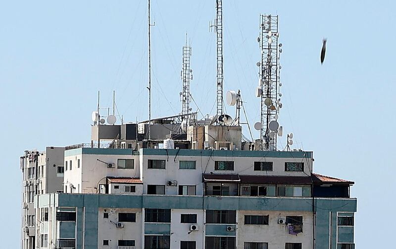 TOPSHOT - An air bomb hits the Jala Tower during an Israeli airstrike in Gaza city controlled by the Palestinian Hamas movement, on May 15, 2021. Israeli air strikes pounded the Gaza Strip, killing 10 members of an extended family and demolishing a key media building, while Palestinian militants launched rockets in return amid violence in the West Bank. Israel's air force targeted the 13-floor Jala Tower housing Qatar-based Al-Jazeera television and the Associated Press news agency. / AFP / Mahmud Hams
