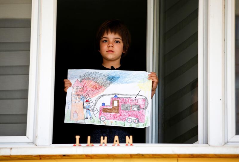 Ilhan Ruvic, 5, with his drawing at his home in Zenica, Bosnia and Herzegovina, April 19. 'I drew firefighters because they are heroes,' said Ilhan. 'I used to draw numbers and letters before isolation... and now I watch a lot of 911 TV series and that is mostly what I draw.' Dado Ruvic / Reuters