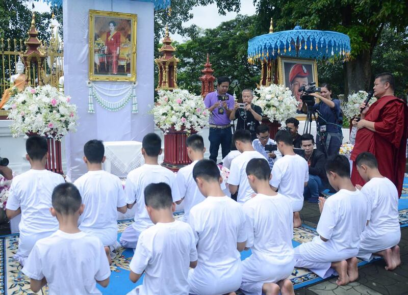 The team offers prayers next to Thai Buddhist monks. Chiangrai Public Relation Office  / EPA