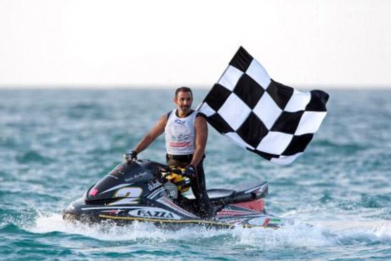 Dubai, January 1, 2011 - Nadir bin Hindi, of the UAE, drives to shore with the checkered flag after winning Heat 1 of the Pro Runabout GP class of the UAE Jet-Ski Championships in Dubai, January 1, 2010. (Jeff Topping/The National) 