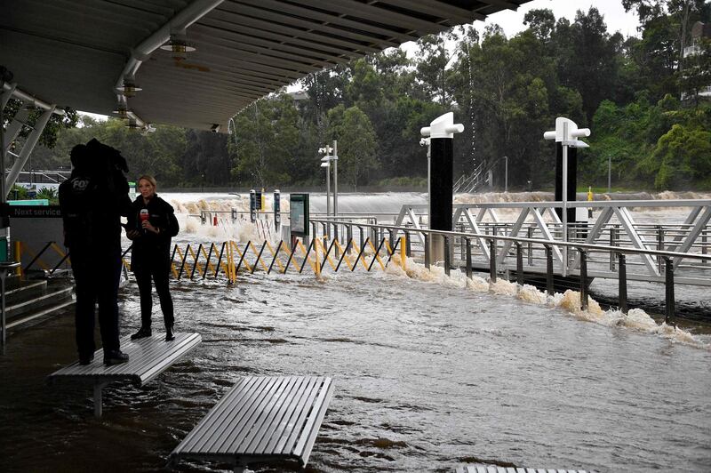 A TV crew provides coverage of the overflowing Parramatta river during heavy rain in Sydney. AFP