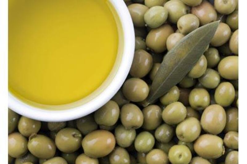 The process of producing oilve oil involves crushing olives in a mill.