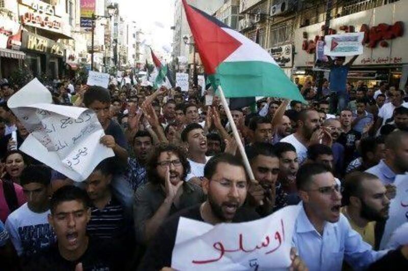 Palestinians hold flags and placards during a protest against the rising cost of living in the West Bank city of Ramallah.