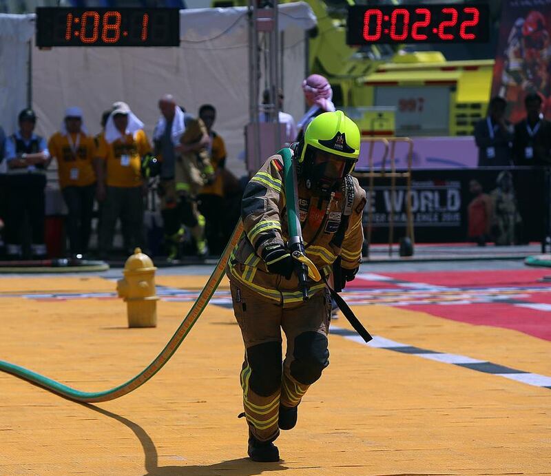 A participant pulls a fully pressurised hose 23m during one of the challenges at the UAE World Fire Fighter Challenge in Abu Dhabi. Satish Kumar / The National